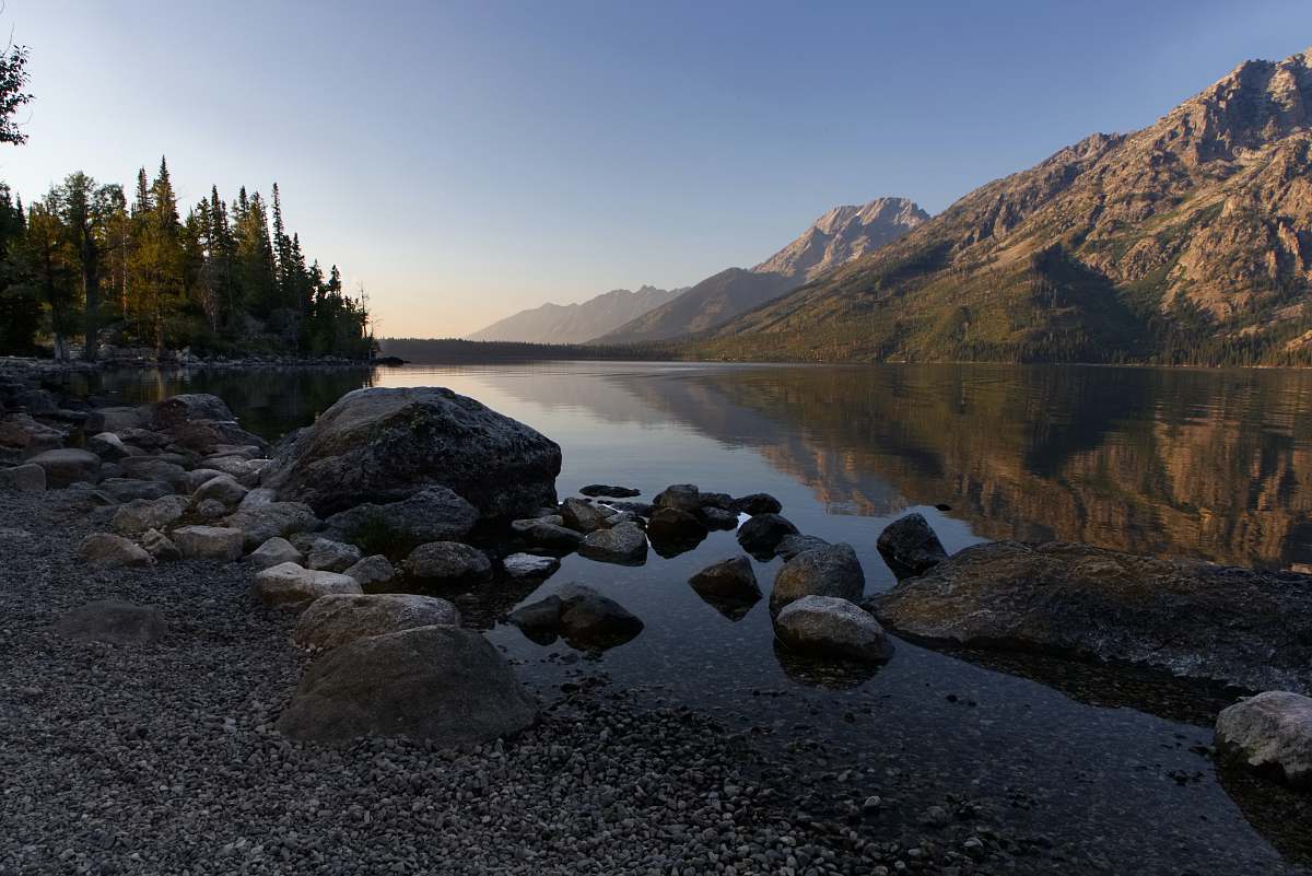 gravel pile of stones beside body of water road
